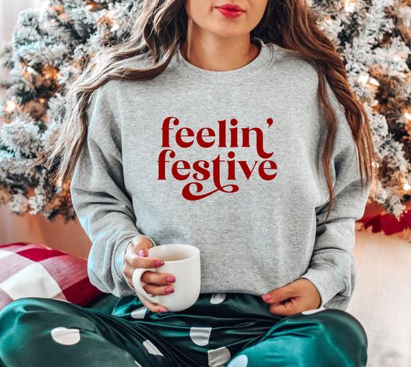 Cozy Feelin' Festive Pullover in various colors, showcasing its soft fabric and unisex design.