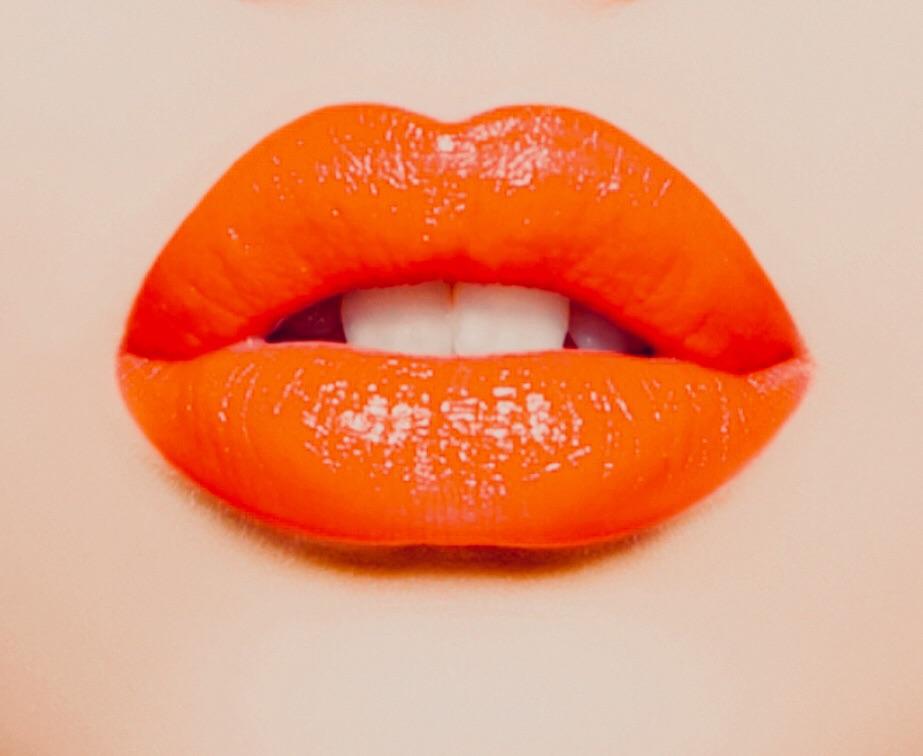 Fetching Lipstick in intense bright orange shade with a glossy finish, showcasing its creamy texture and vibrant color.