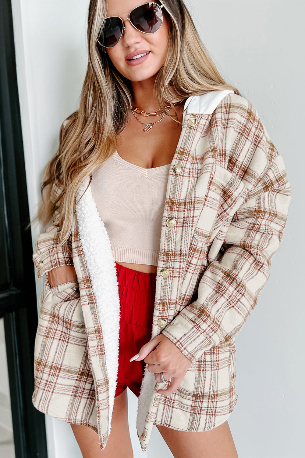 Fiery red sherpa lined hooded plaid jacket with side pockets, showcasing a trendy plaid design and solid-color hood.