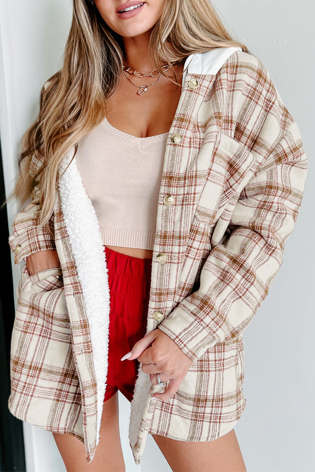 Fiery red sherpa lined hooded plaid jacket with side pockets, showcasing a trendy plaid design and solid-color hood.