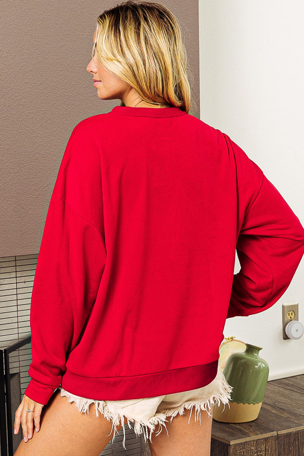 Fiery red sweatshirt featuring a shiny SANTA BABY graphic, perfect for holiday celebrations, with a crew neck and loose fit style.