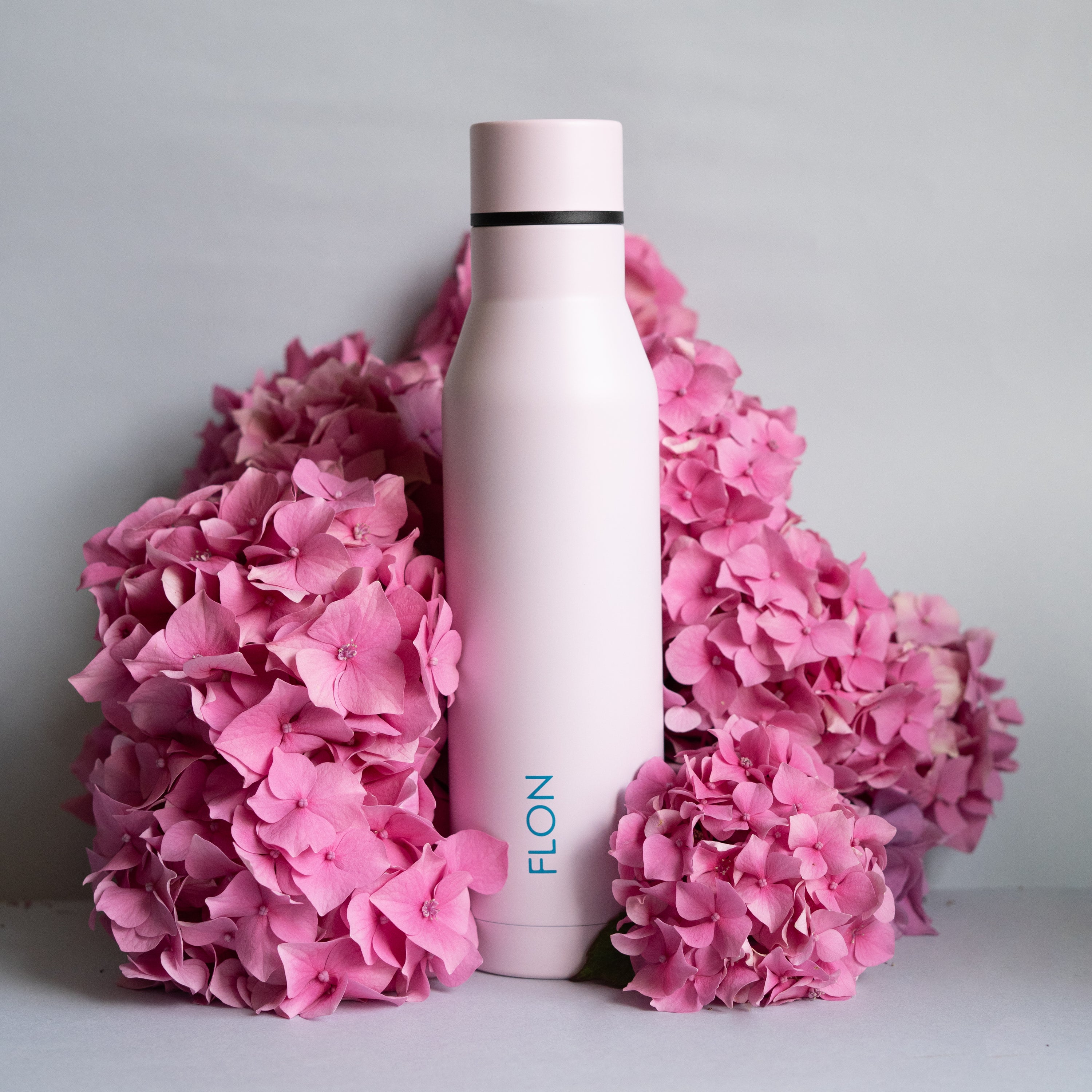 FLON Water Bottle 500ml in vibrant colors, showcasing its stainless steel body and sturdy design.