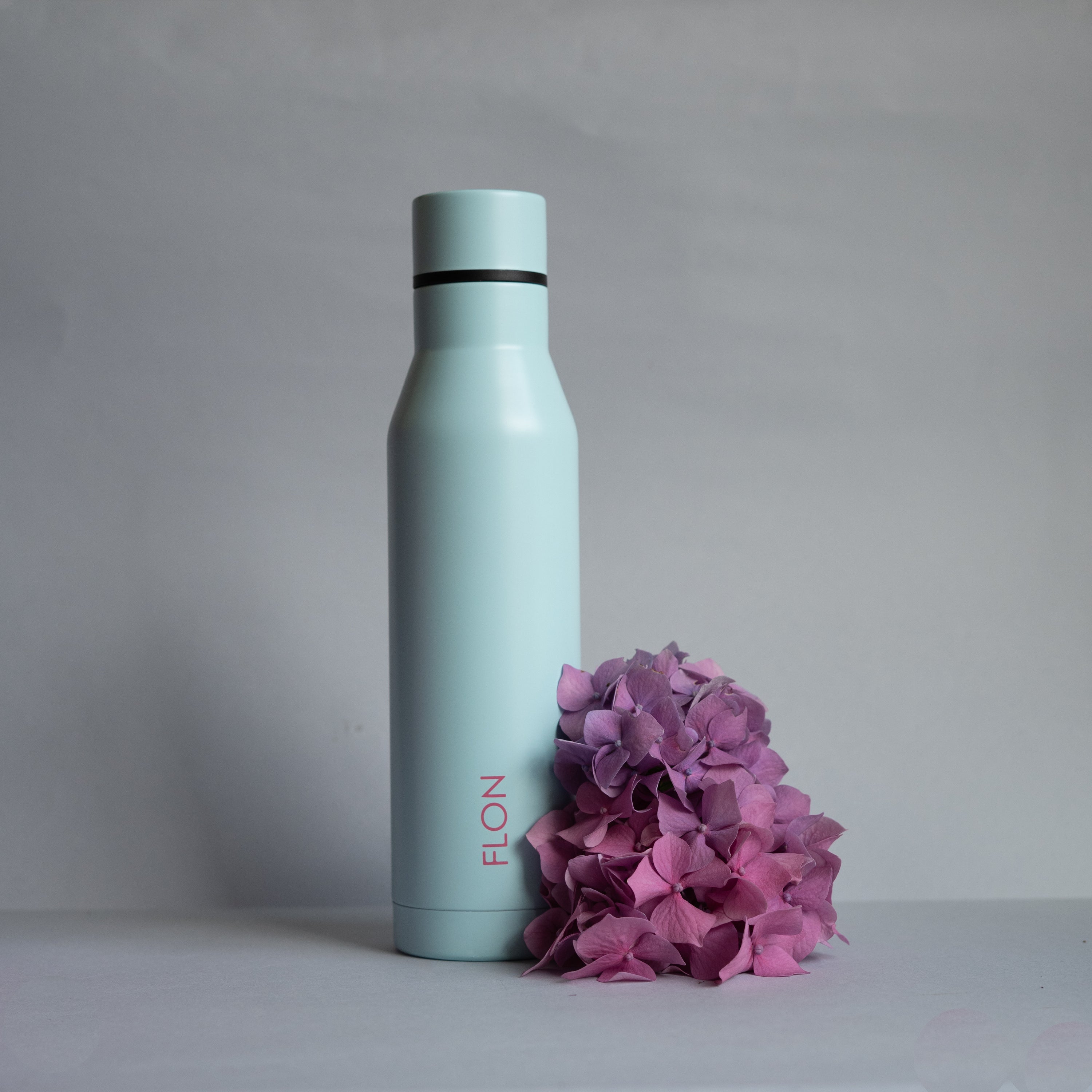 FLON Water Bottle 500ml in vibrant colors, showcasing its stainless steel body and sturdy design.