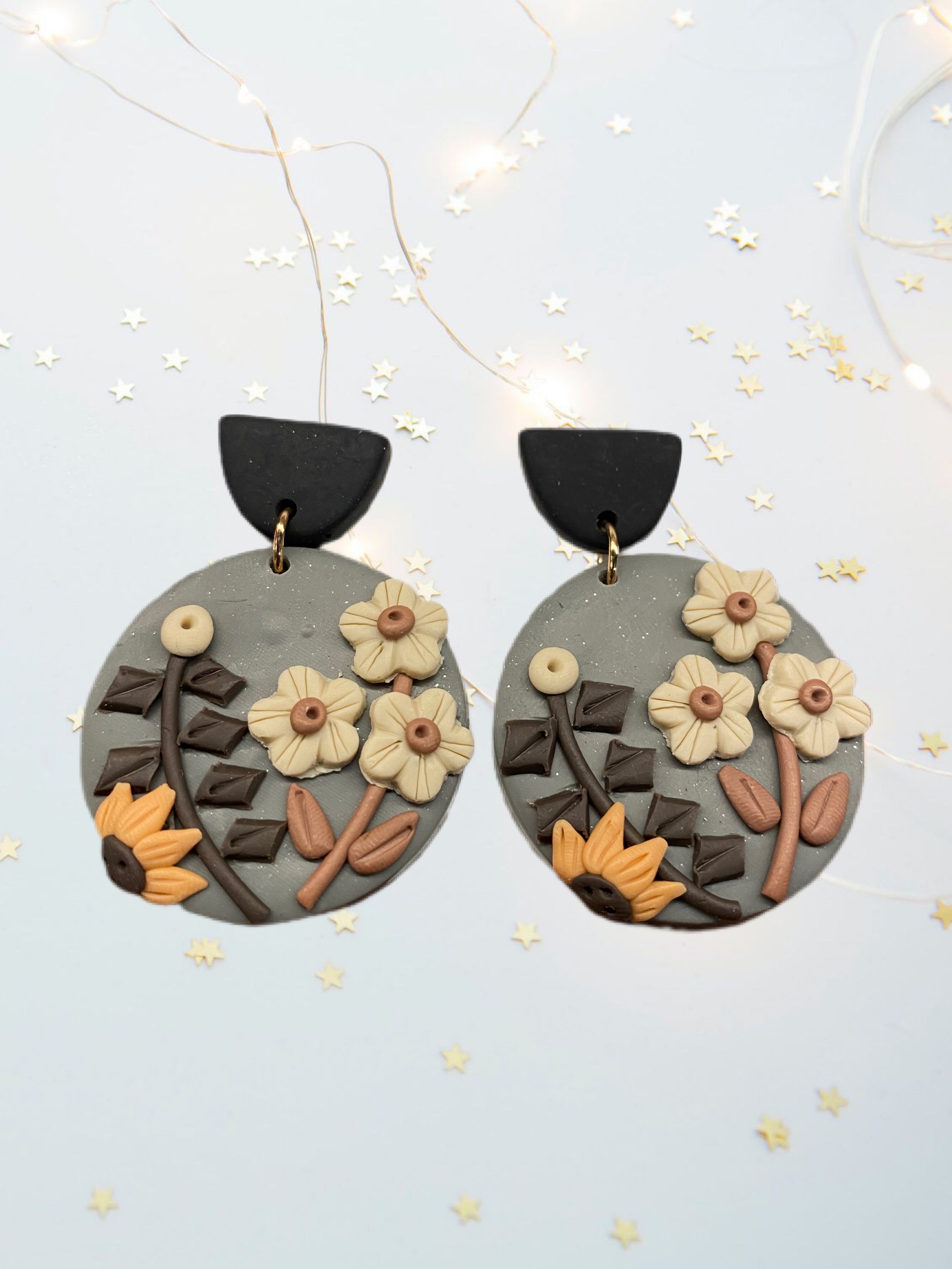 A pair of beautifully handcrafted floral clay earrings featuring intricate floral designs in vibrant colors.