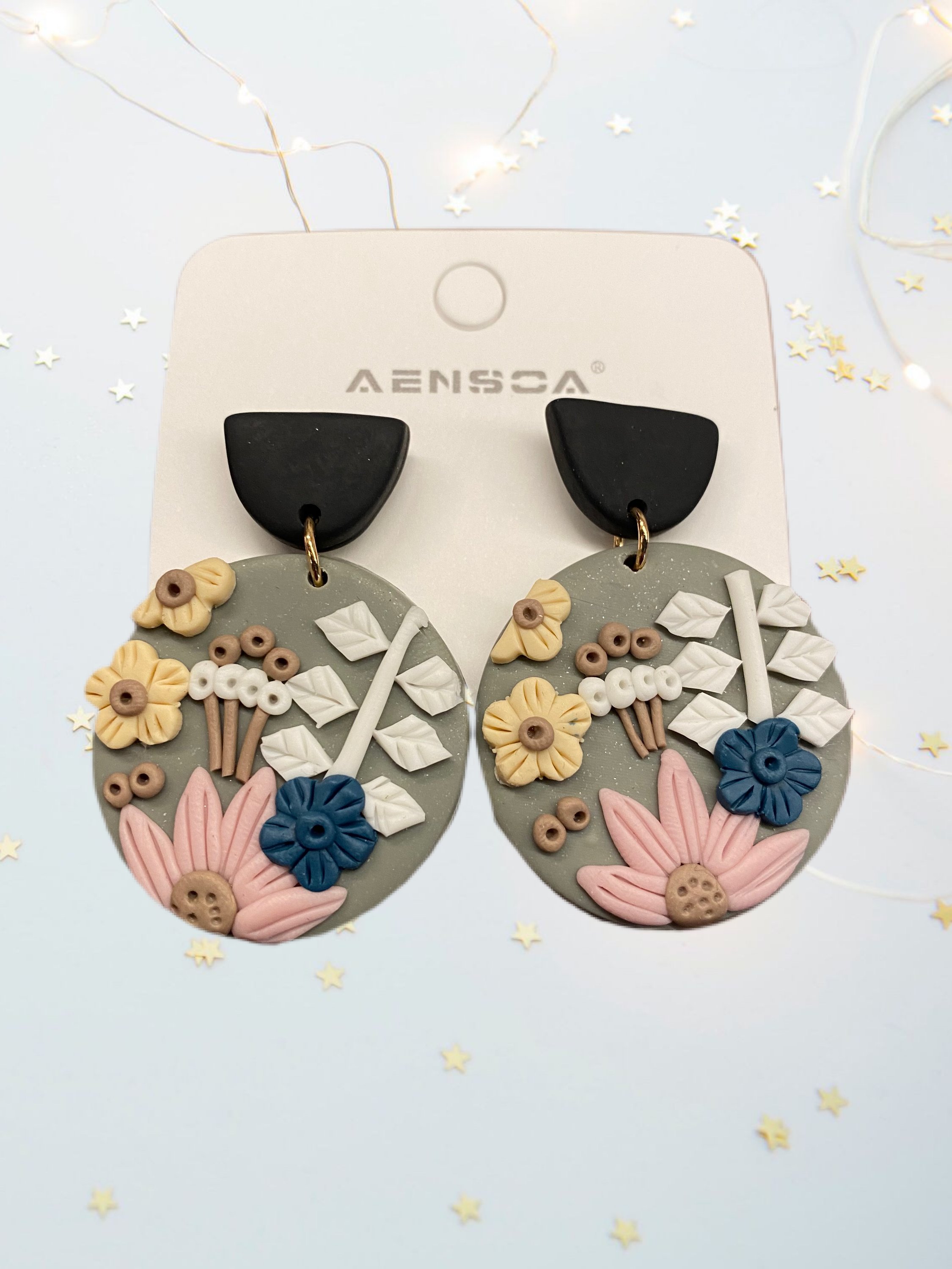 A pair of beautifully handcrafted floral clay earrings featuring intricate floral designs in vibrant colors.