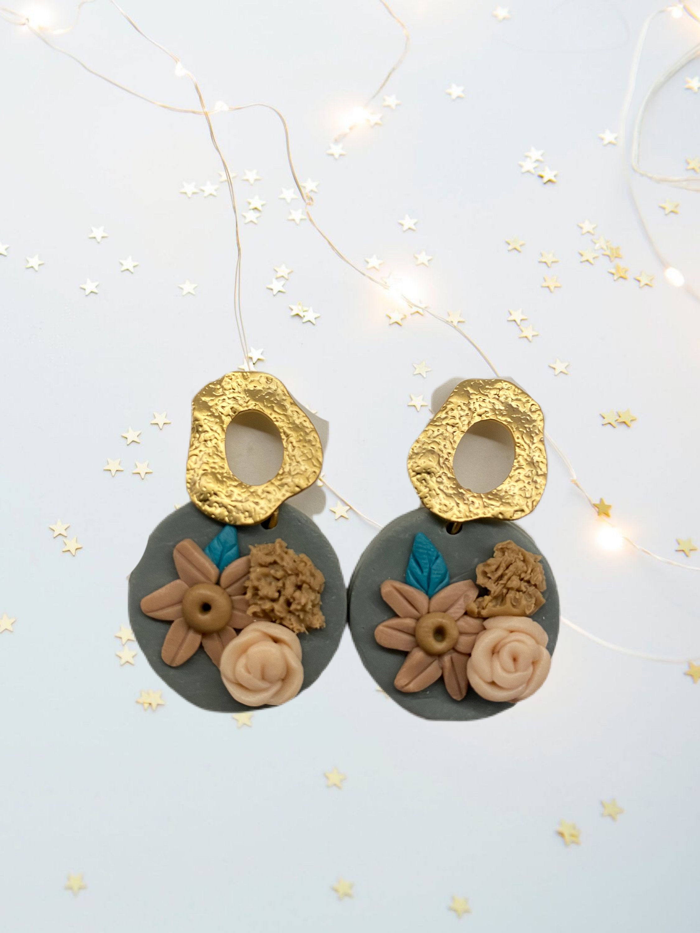 A pair of beautifully handcrafted floral clay earrings featuring intricate floral designs in vibrant colors.