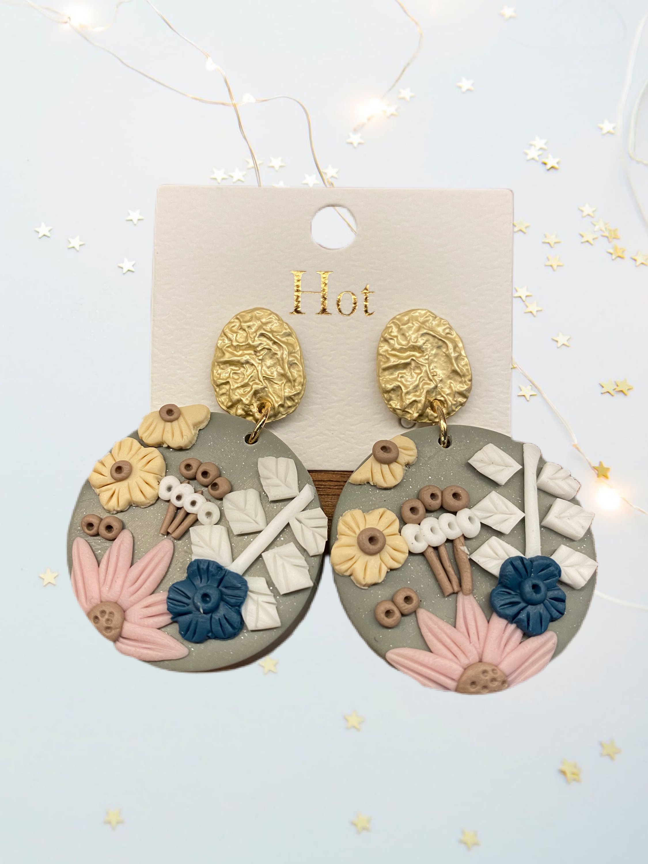 A pair of beautifully handcrafted floral clay earrings featuring intricate floral designs in vibrant colors.