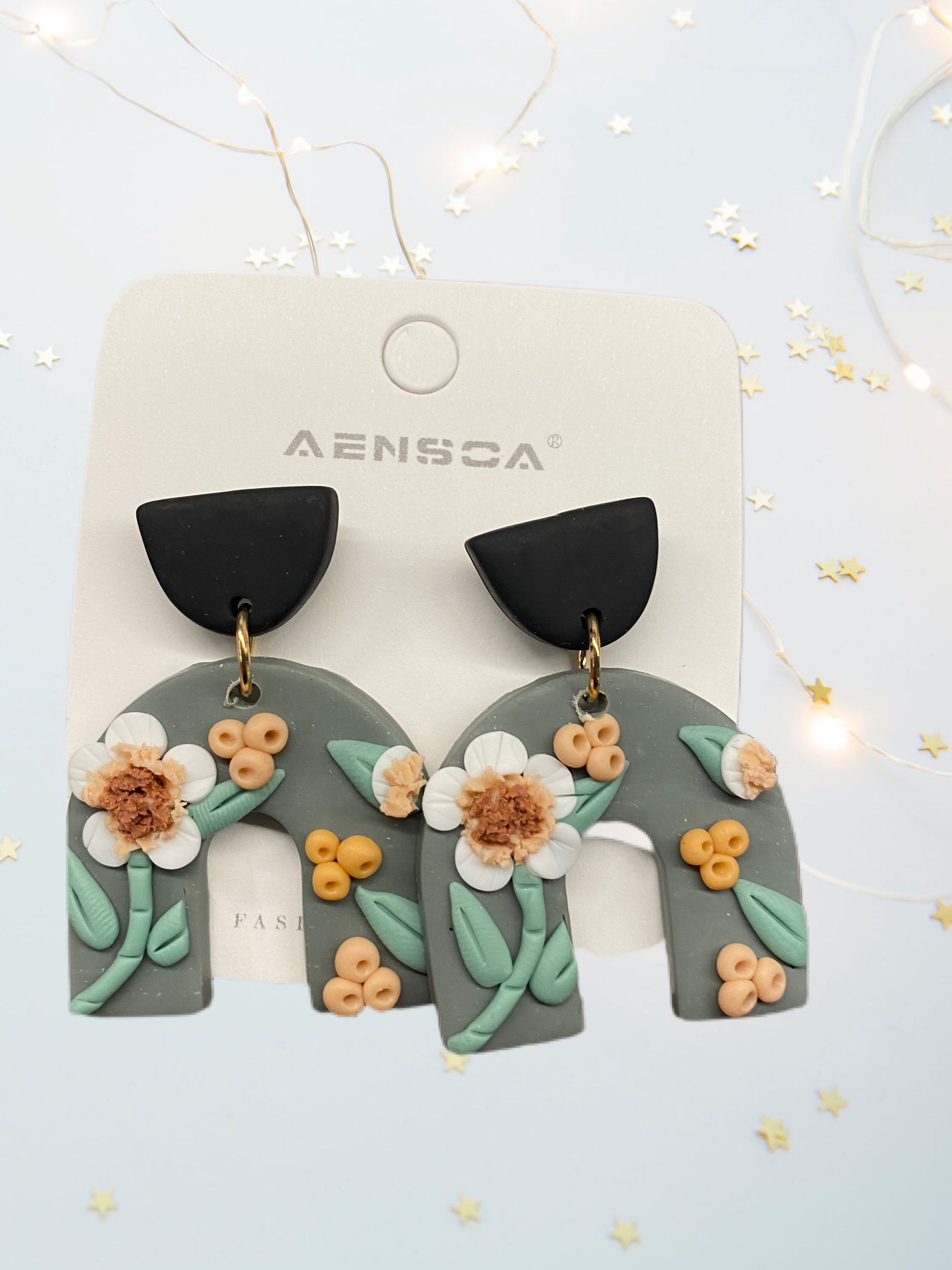 A pair of beautifully handcrafted floral clay earrings featuring intricate floral designs in vibrant colors.