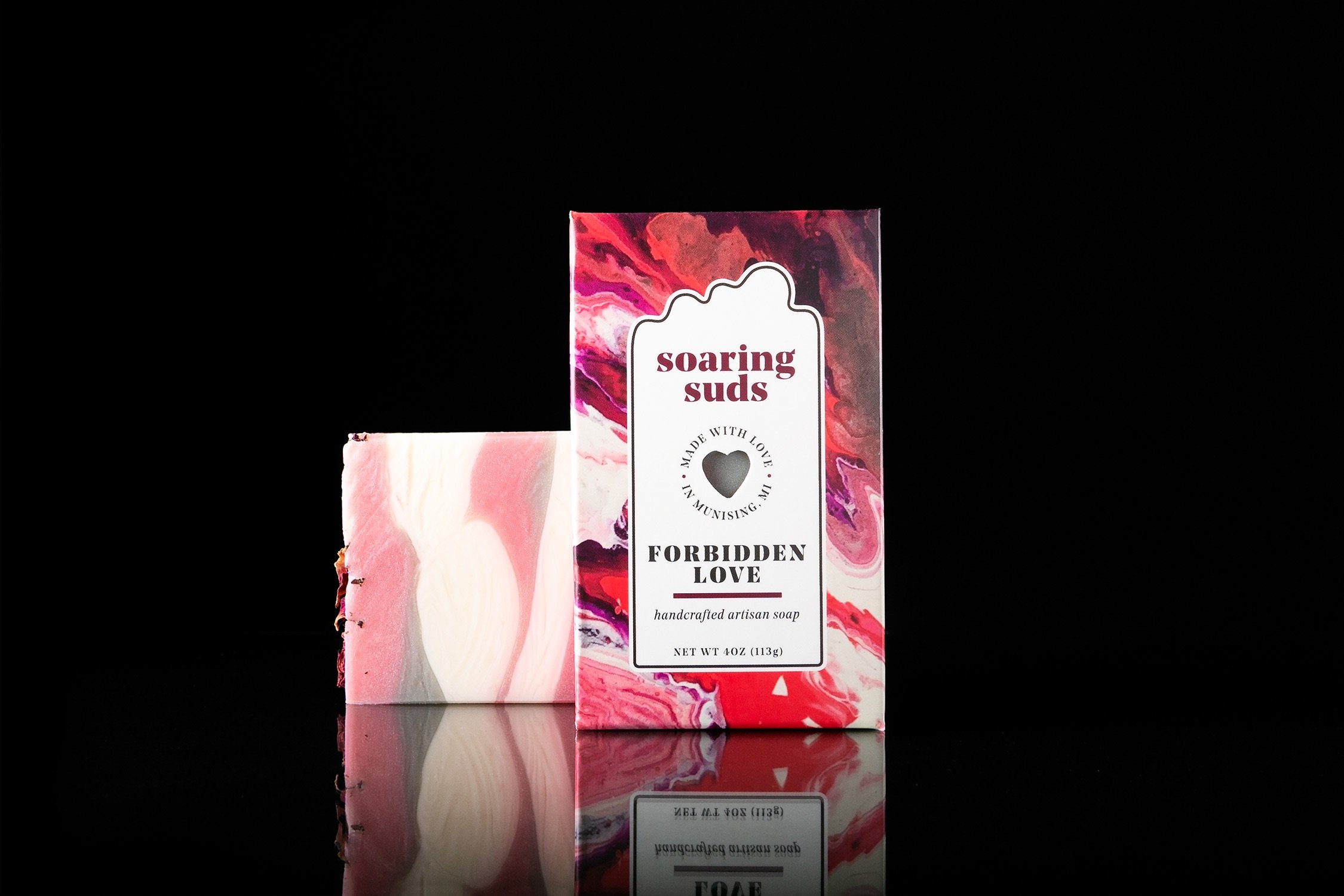 A beautifully crafted bar of Forbidden Love Artisan Soap with a bright citrus and rose design, showcasing its unique texture and colors.