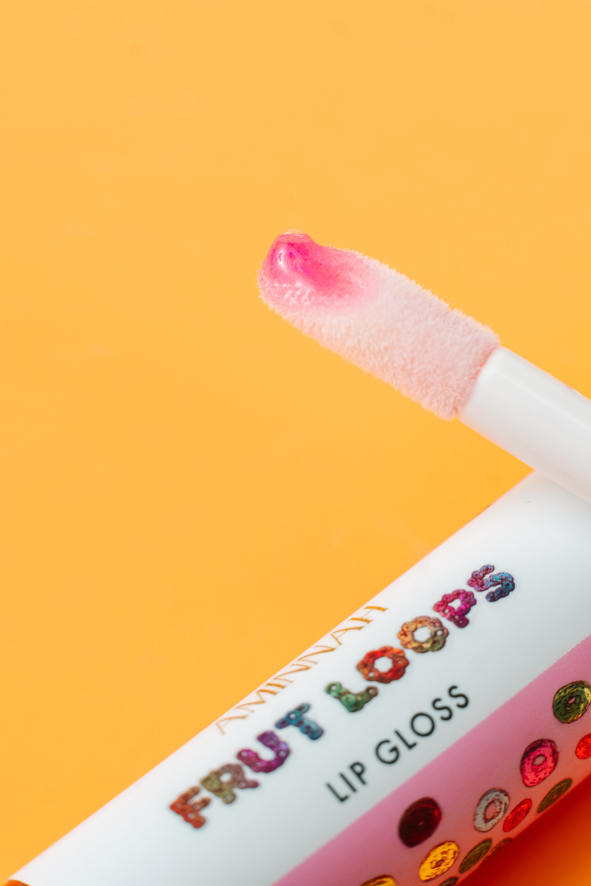 Frut Loops Lip Gloss in colorful packaging, showcasing its fruity flavor and high-shine finish.