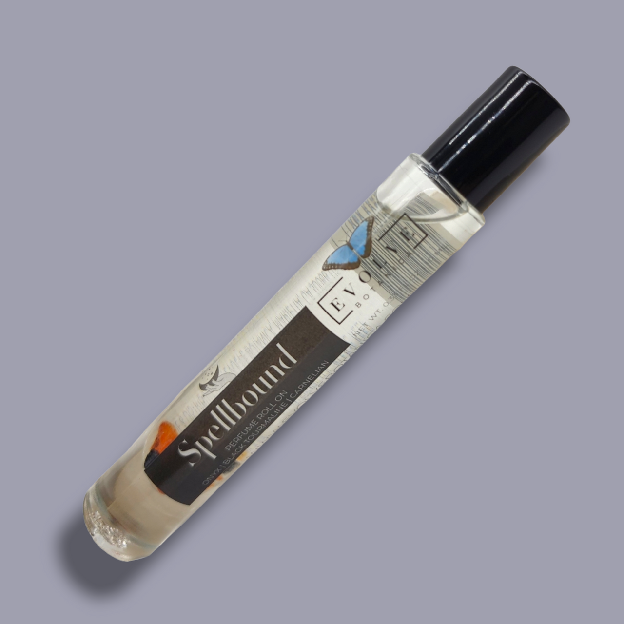 Spellbound Gemstone Perfume Roll On in a glass bottle with stainless steel roller ball, featuring a blend of amber, tobacco, and honey notes.