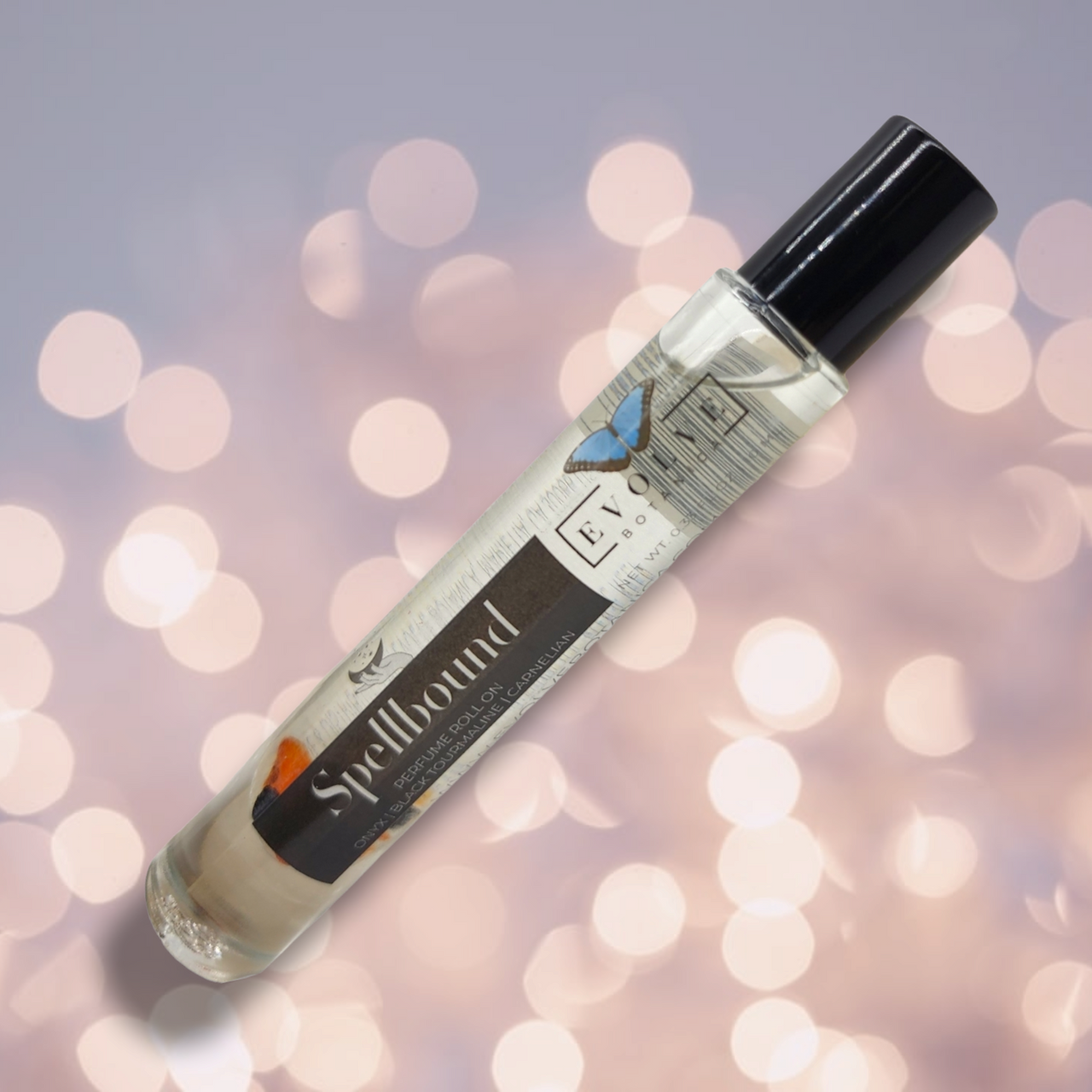 Spellbound Gemstone Perfume Roll On in a glass bottle with stainless steel roller ball, featuring a blend of amber, tobacco, and honey notes.