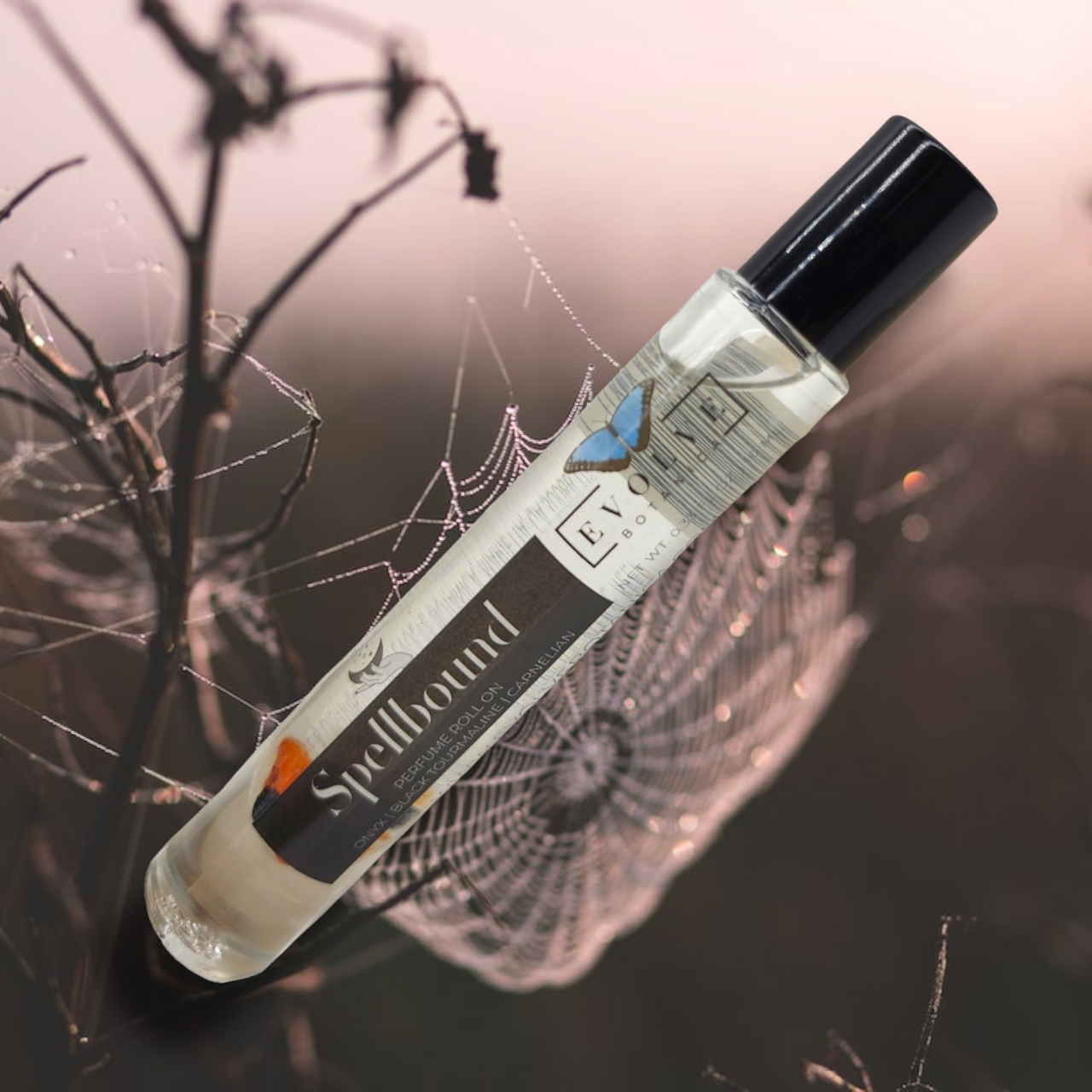 Spellbound Gemstone Perfume Roll On in a glass bottle with stainless steel roller ball, featuring a blend of amber, tobacco, and honey notes.