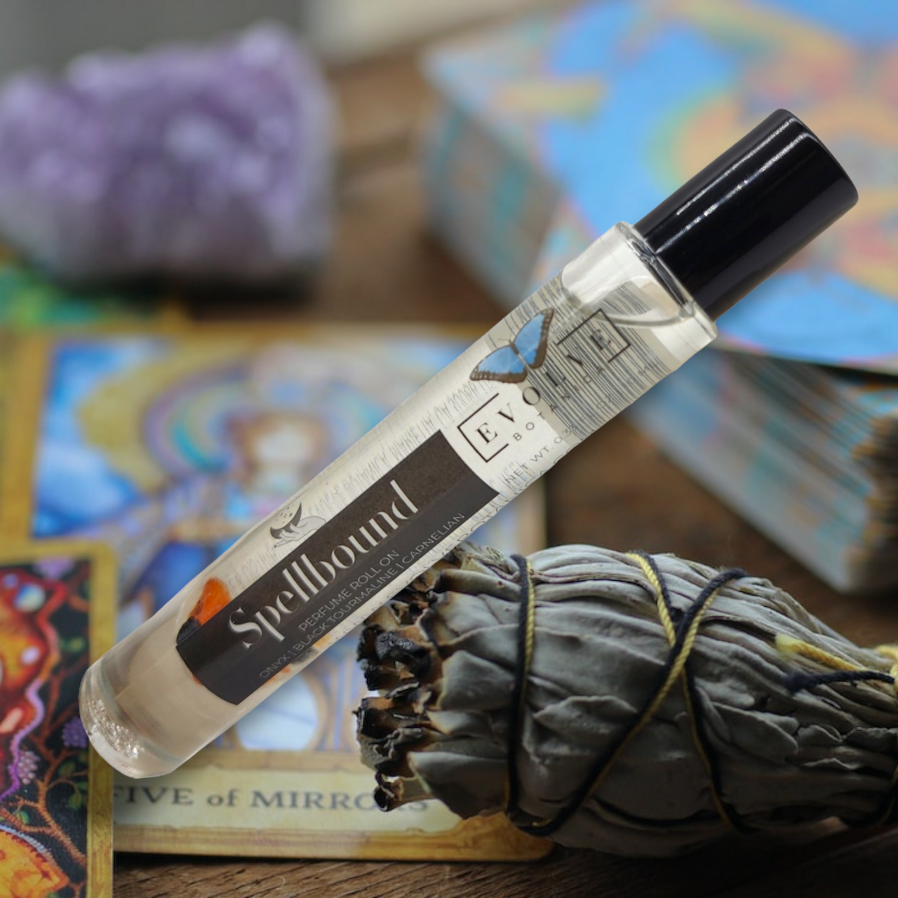 Spellbound Gemstone Perfume Roll On in a glass bottle with stainless steel roller ball, featuring a blend of amber, tobacco, and honey notes.