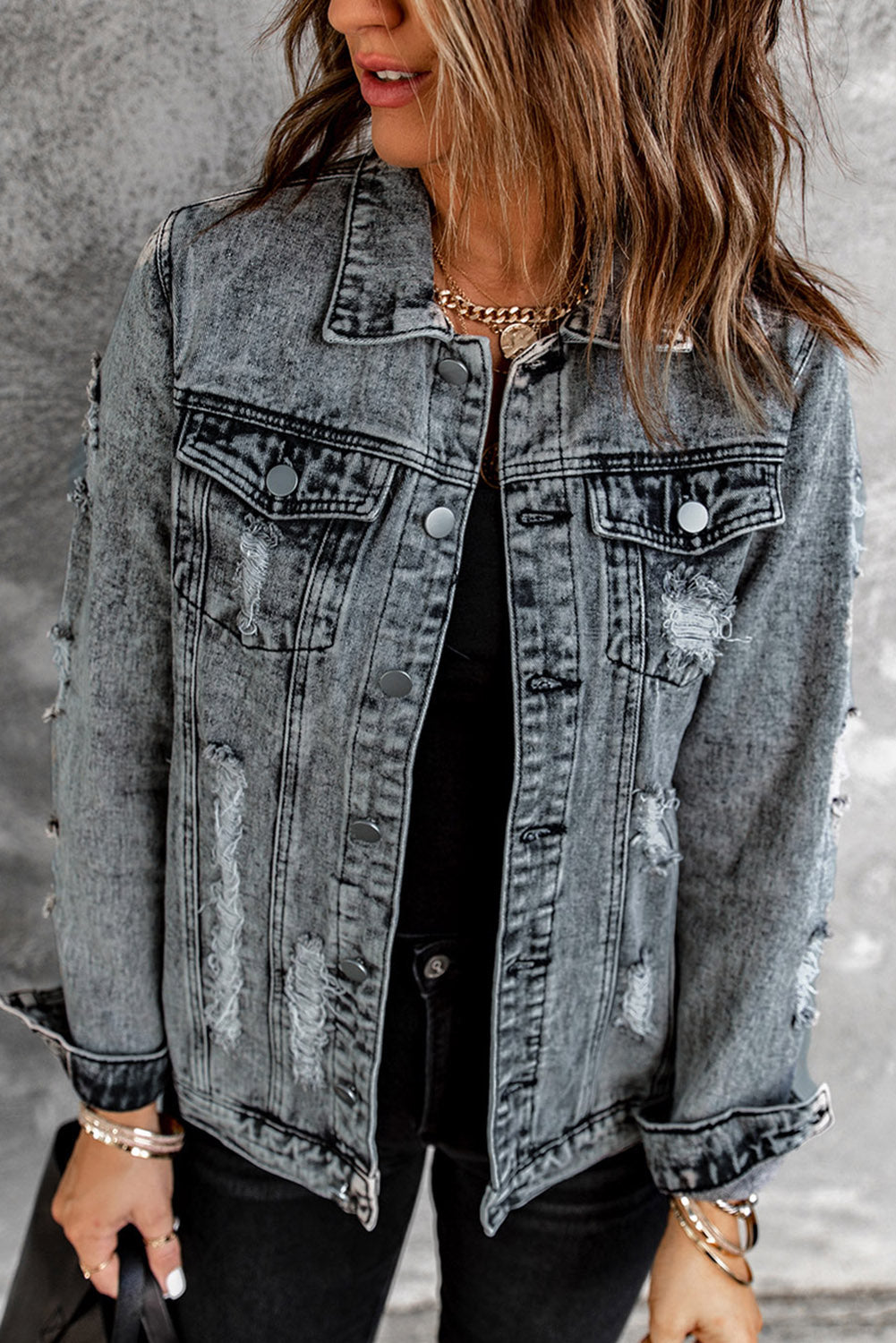 Gray distressed denim jacket featuring buttoned closure, turn down collar, and long sleeves, perfect for stylish layering.