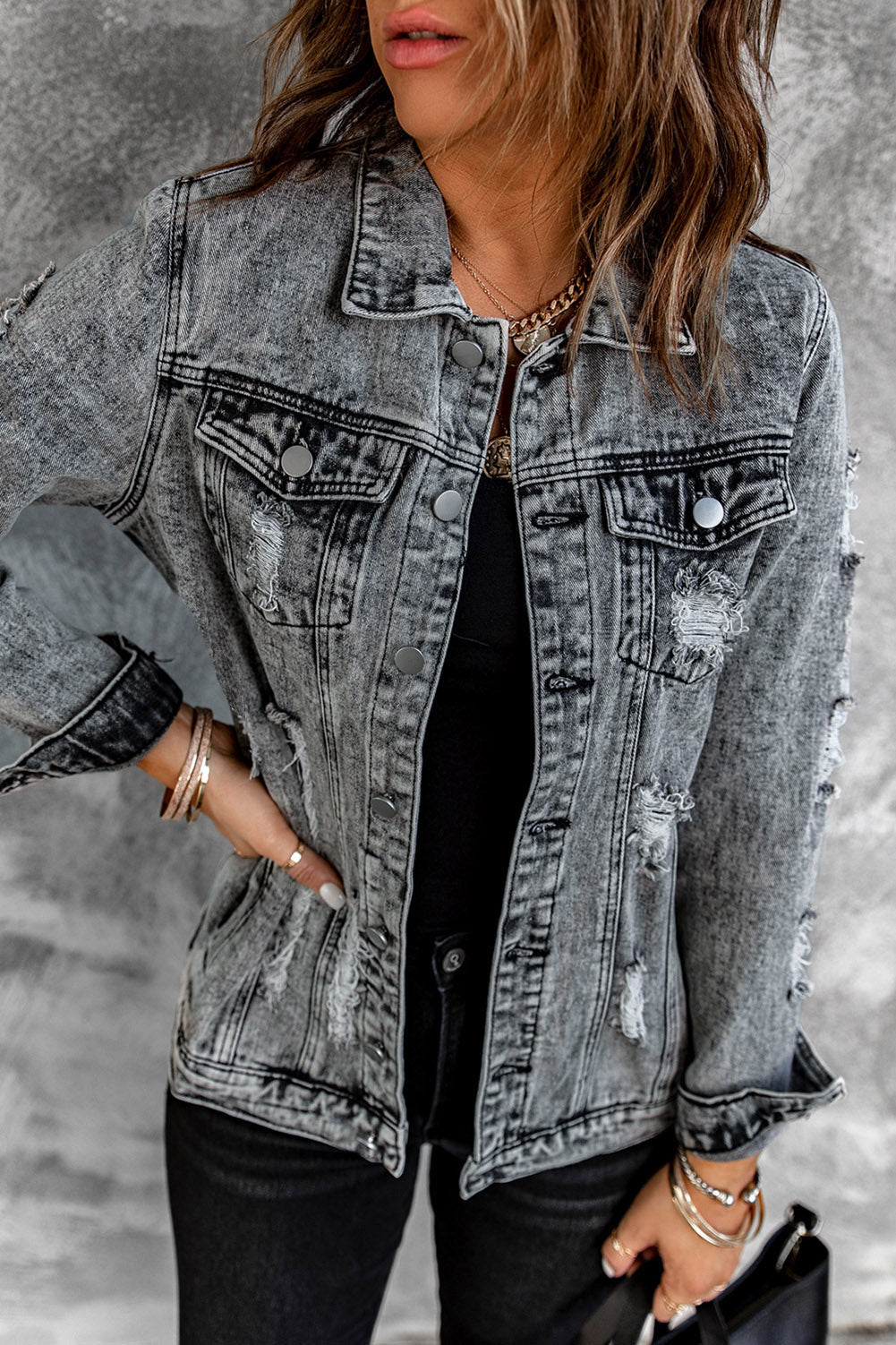 Gray distressed denim jacket featuring buttoned closure, turn down collar, and long sleeves, perfect for stylish layering.