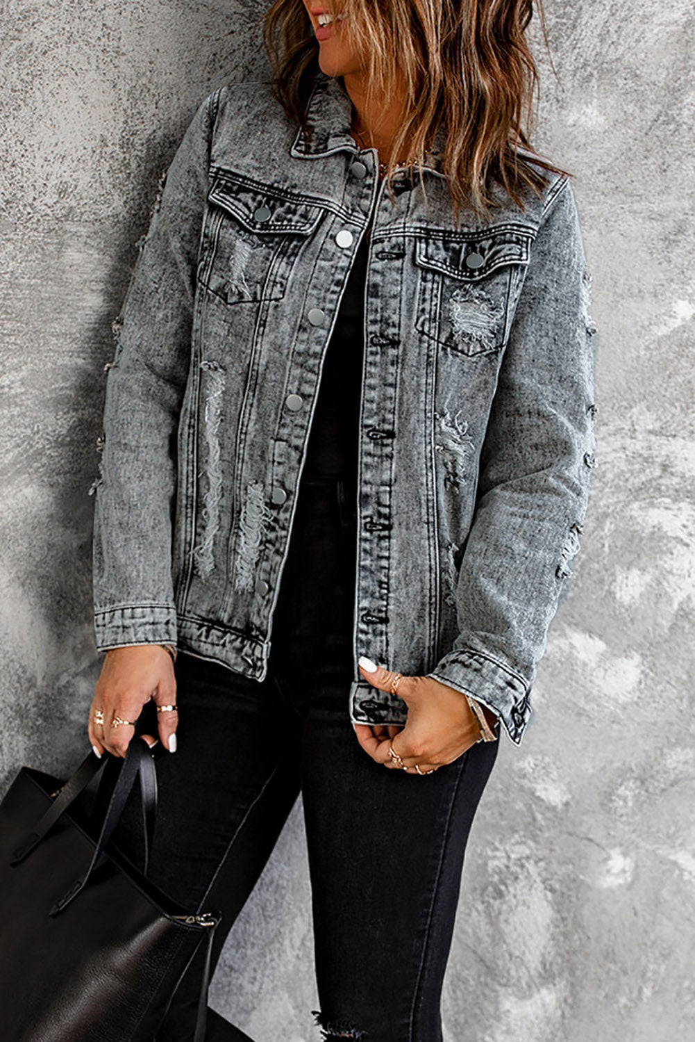 Gray distressed denim jacket featuring buttoned closure, turn down collar, and long sleeves, perfect for stylish layering.