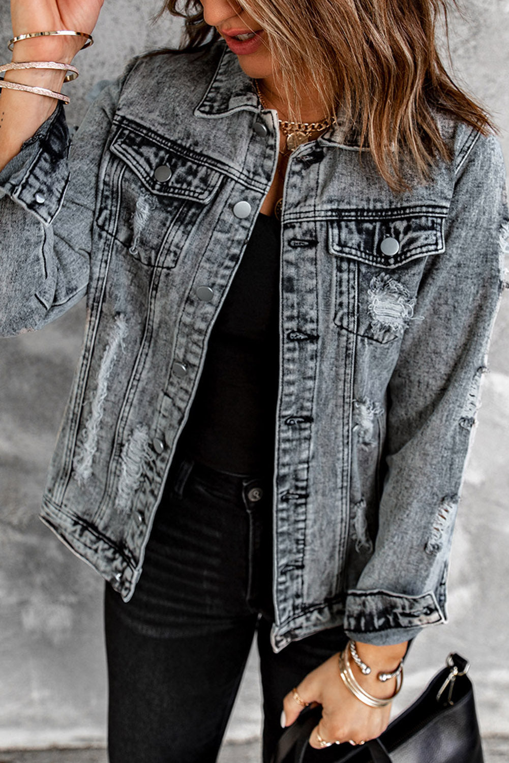 Gray distressed denim jacket featuring buttoned closure, turn down collar, and long sleeves, perfect for stylish layering.