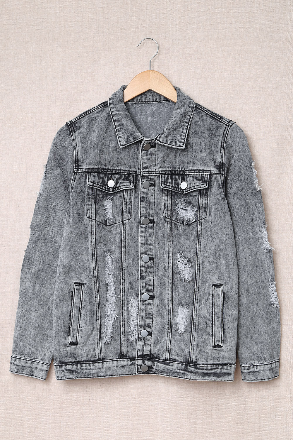 Gray distressed denim jacket featuring buttoned closure, turn down collar, and long sleeves, perfect for stylish layering.