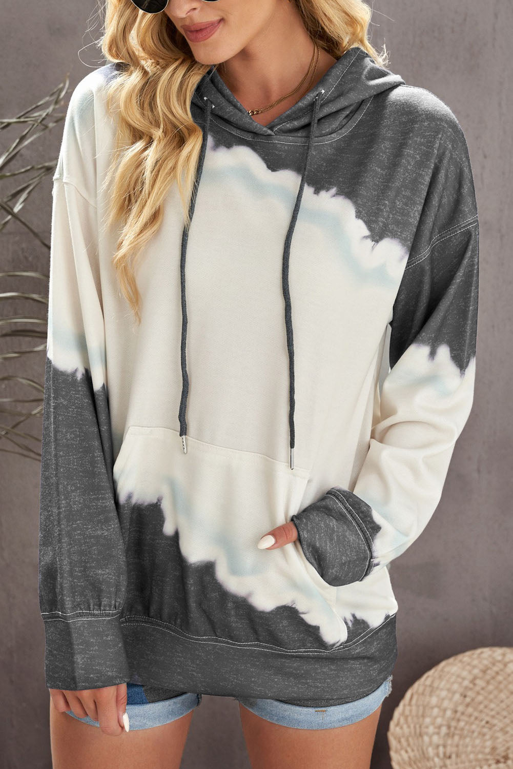 Gray hooded sweatshirt featuring a stylish tie-dye print and a functional front pocket, perfect for casual wear.