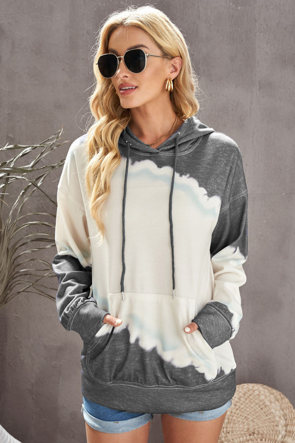 Gray hooded sweatshirt featuring a stylish tie-dye print and a functional front pocket, perfect for casual wear.