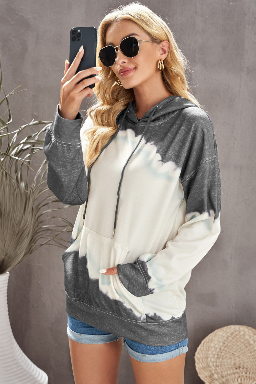 Gray hooded sweatshirt featuring a stylish tie-dye print and a functional front pocket, perfect for casual wear.