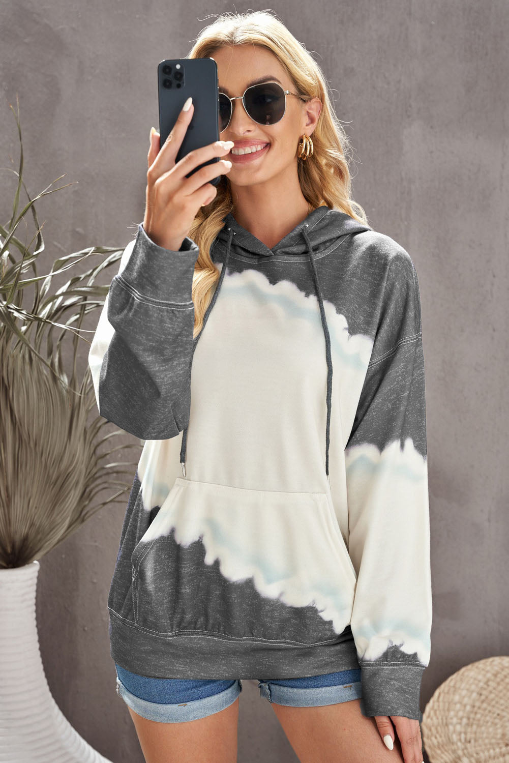 Gray hooded sweatshirt featuring a stylish tie-dye print and a functional front pocket, perfect for casual wear.