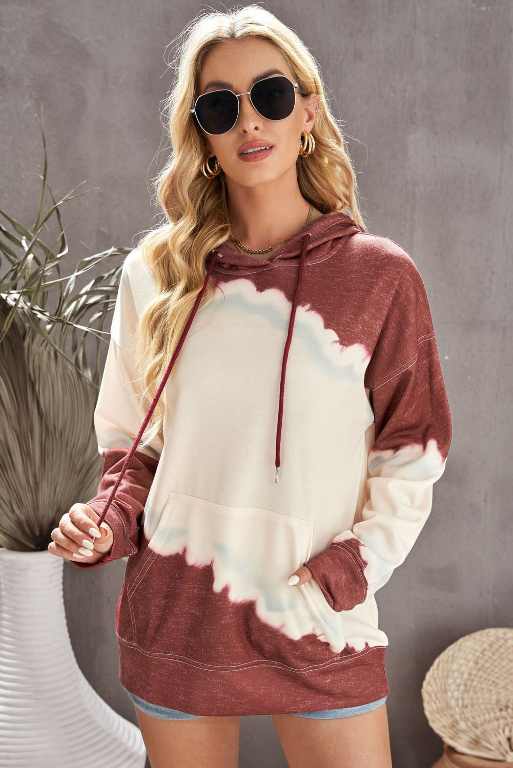 Gray hooded sweatshirt featuring a stylish tie-dye print and a functional front pocket, perfect for casual wear.