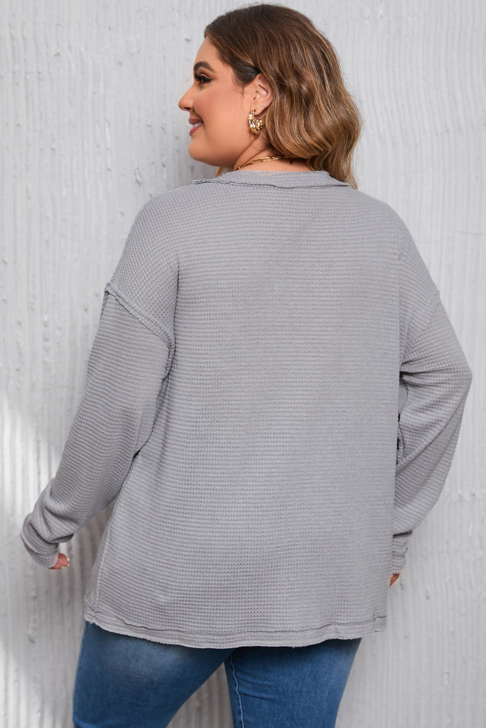 Gray Plus Size V Neck Raw Edge Long Sleeve Top displayed on a mannequin, showcasing its relaxed fit and trendy design.