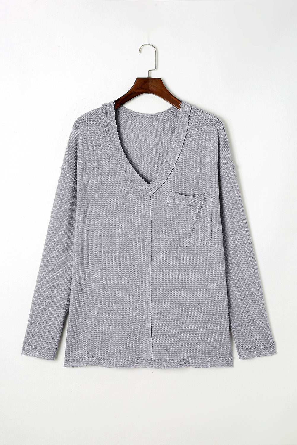 Gray Plus Size V Neck Raw Edge Long Sleeve Top displayed on a mannequin, showcasing its relaxed fit and trendy design.