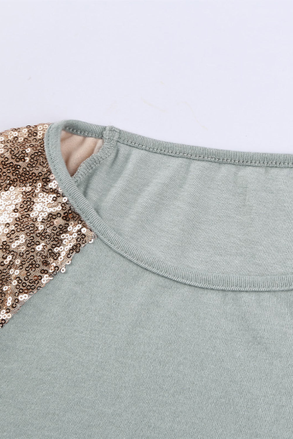 Gray long sleeve top with sequin shoulder detailing, showcasing a classic round neck and soft knit fabric.