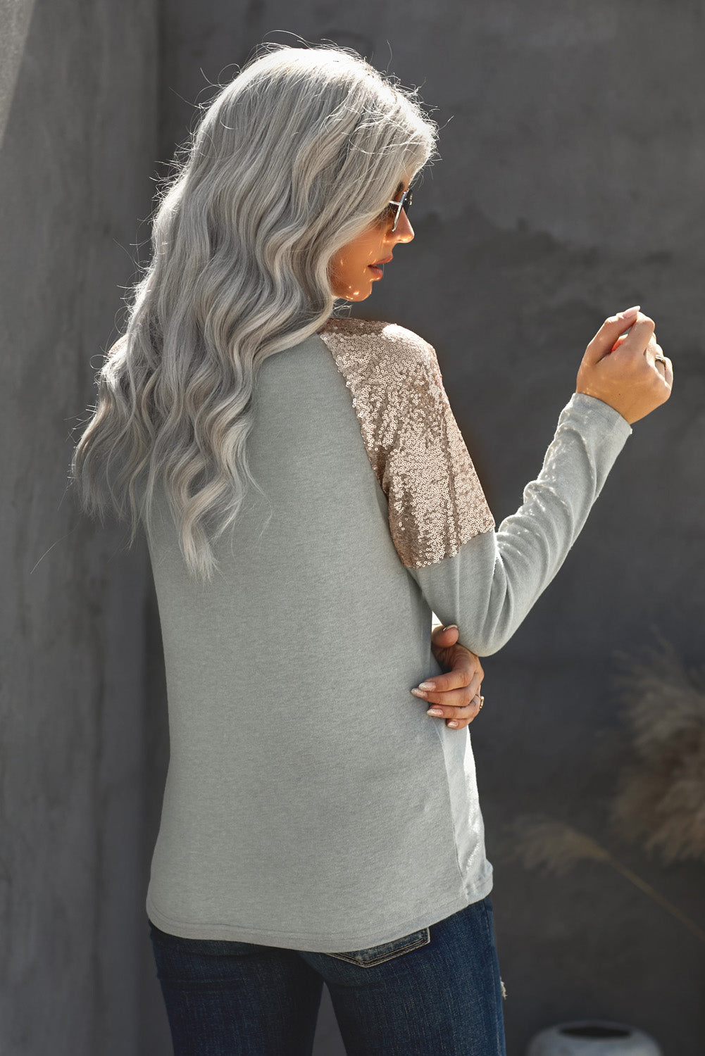 Gray long sleeve top with sequin shoulder detailing, showcasing a classic round neck and soft knit fabric.