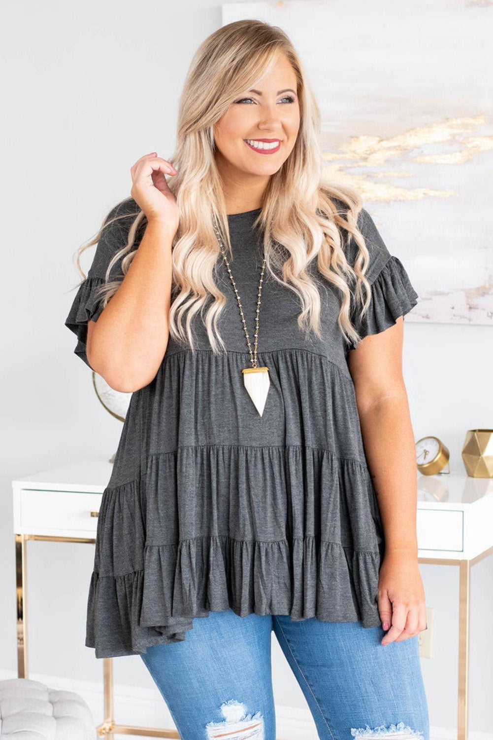 Gray tiered ruffled short sleeve plus size blouse displayed on a mannequin, showcasing its elegant design and comfortable fit.