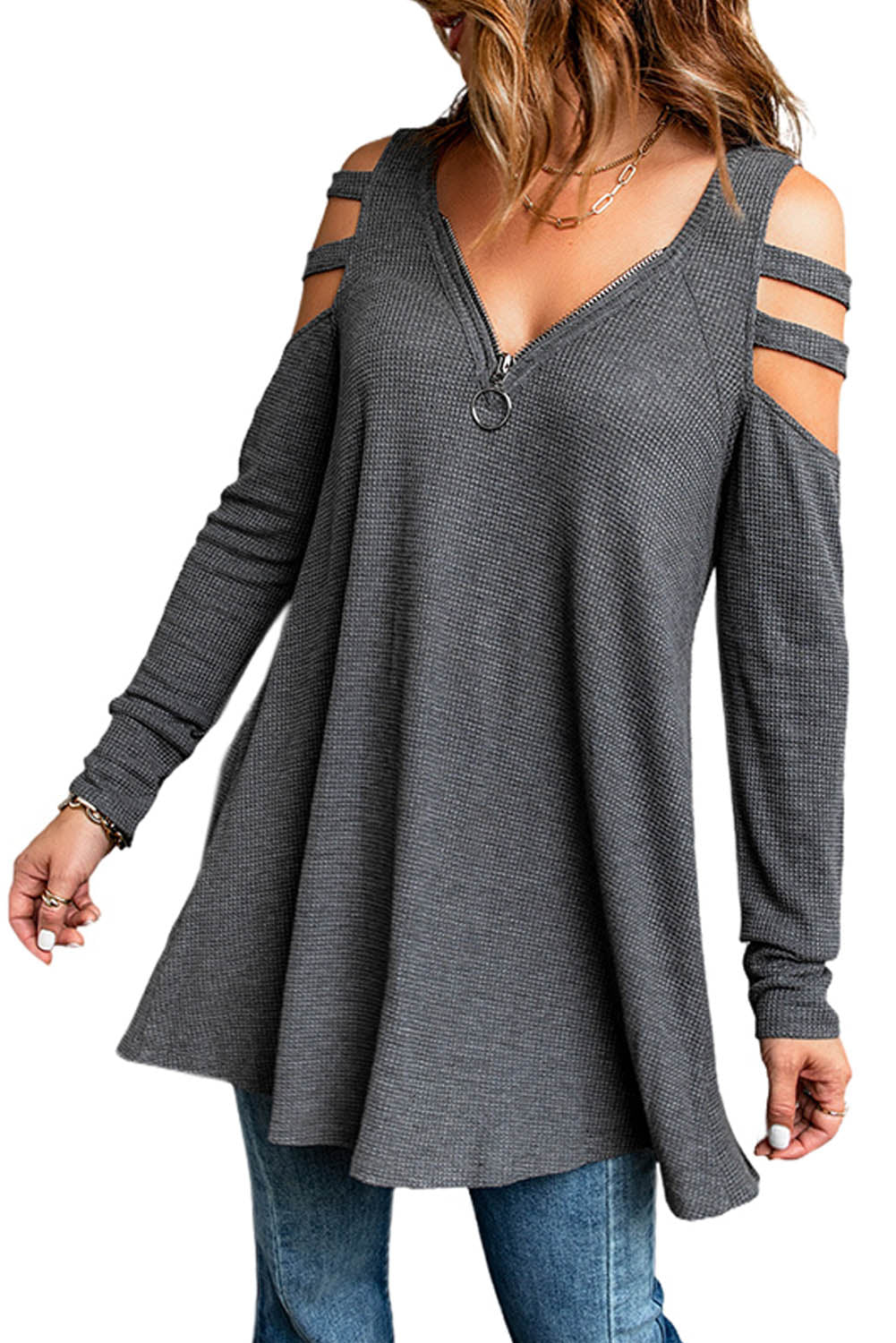 Gray long sleeve top with zip neck and cut-out design, featuring a textured waffle knit fabric and a loose fit with a ruffled hemline.