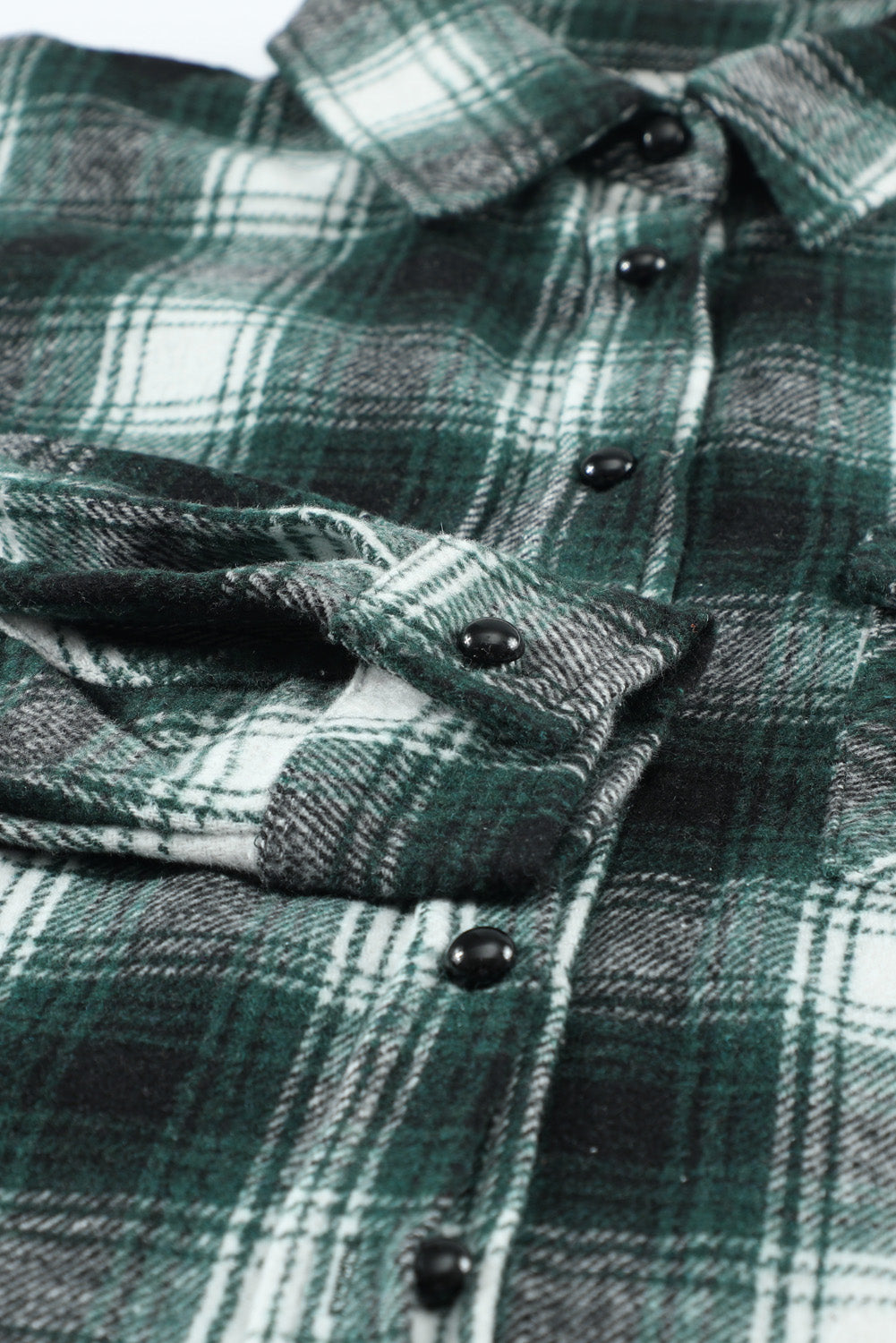 Green plaid shacket with buttons and front pockets, featuring a loose fit and turn-down collar, perfect for casual wear.