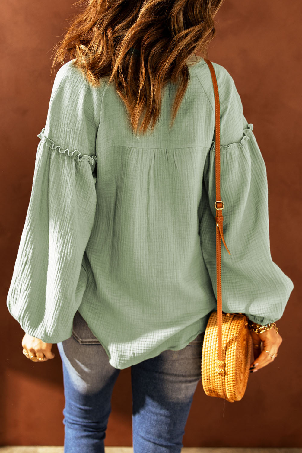 A stylish green casual top featuring balloon sleeves, a split neckline, and snap button closures, perfect for a chic and comfortable look.