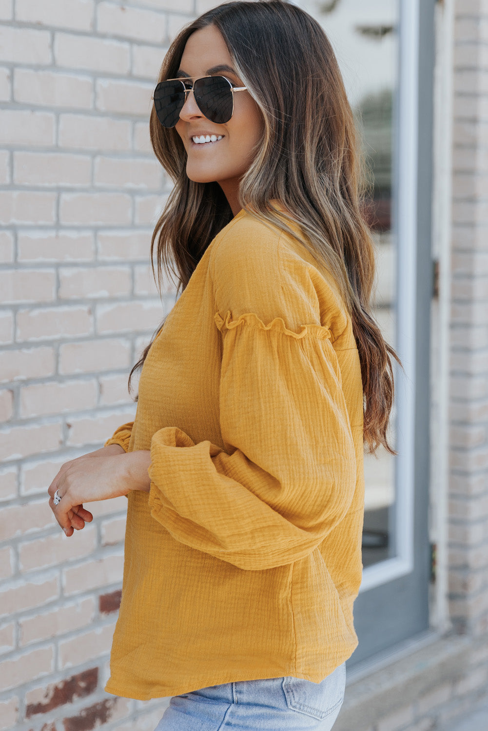 A stylish green casual top featuring balloon sleeves, a split neckline, and snap button closures, perfect for a chic and comfortable look.