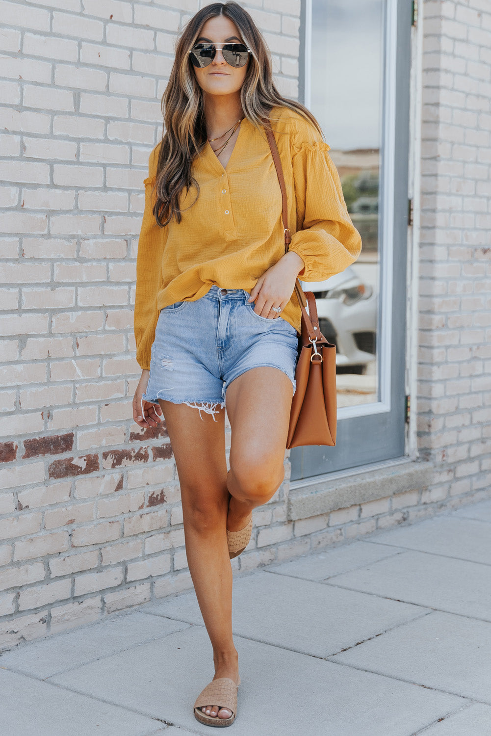 A stylish green casual top featuring balloon sleeves, a split neckline, and snap button closures, perfect for a chic and comfortable look.