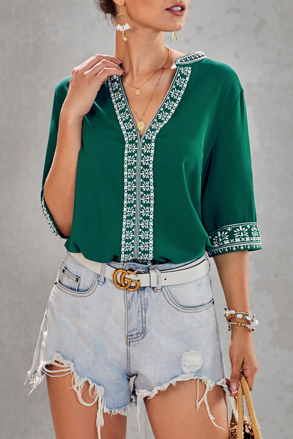 A stylish green boho blouse featuring a v-neckline and half sleeves with floral details, perfect for casual outings.