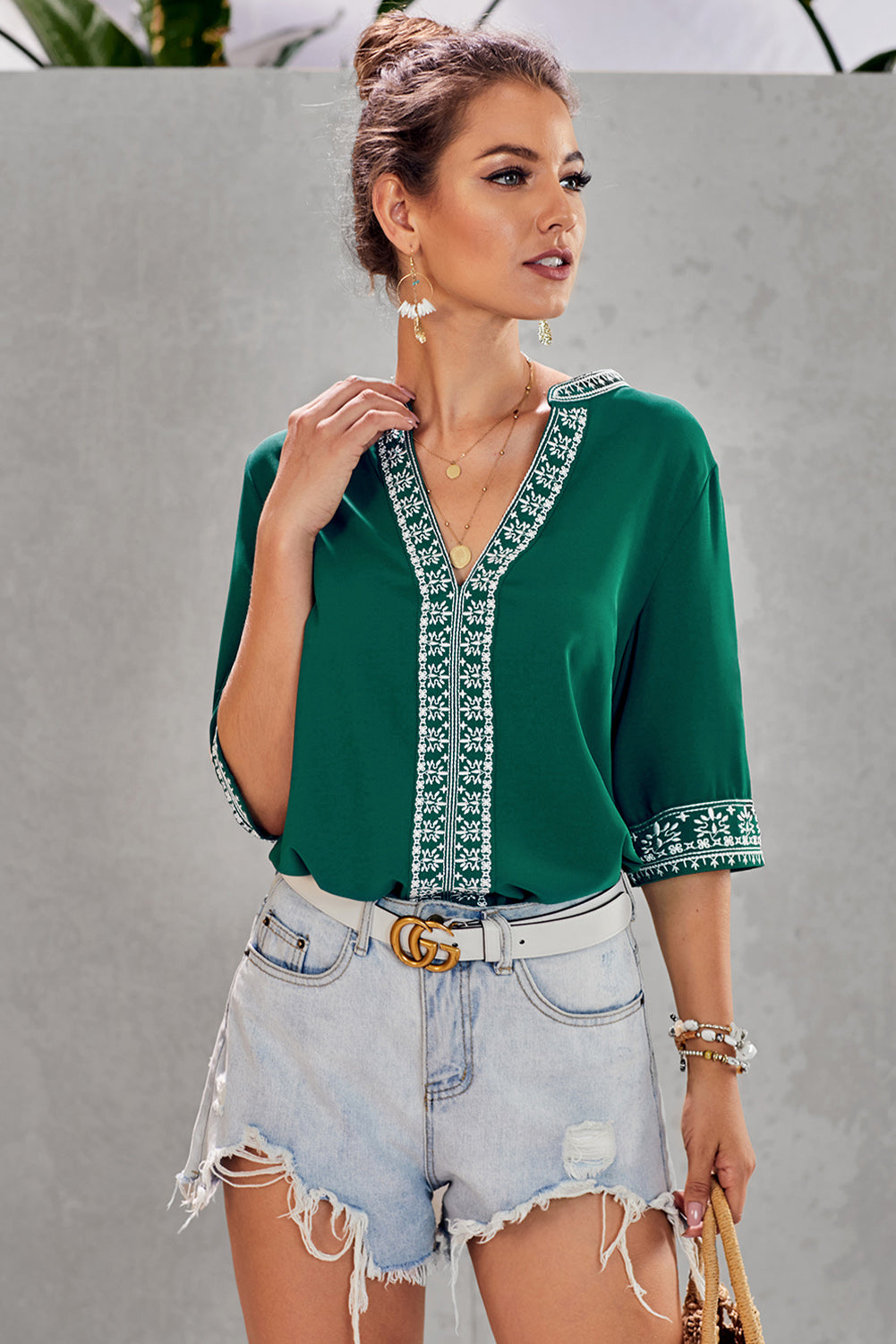 A stylish green boho blouse featuring a v-neckline and half sleeves with floral details, perfect for casual outings.