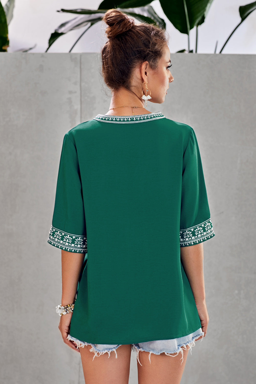 A stylish green boho blouse featuring a v-neckline and half sleeves with floral details, perfect for casual outings.