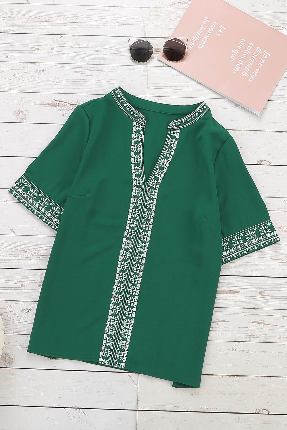 A stylish green boho blouse featuring a v-neckline and half sleeves with floral details, perfect for casual outings.