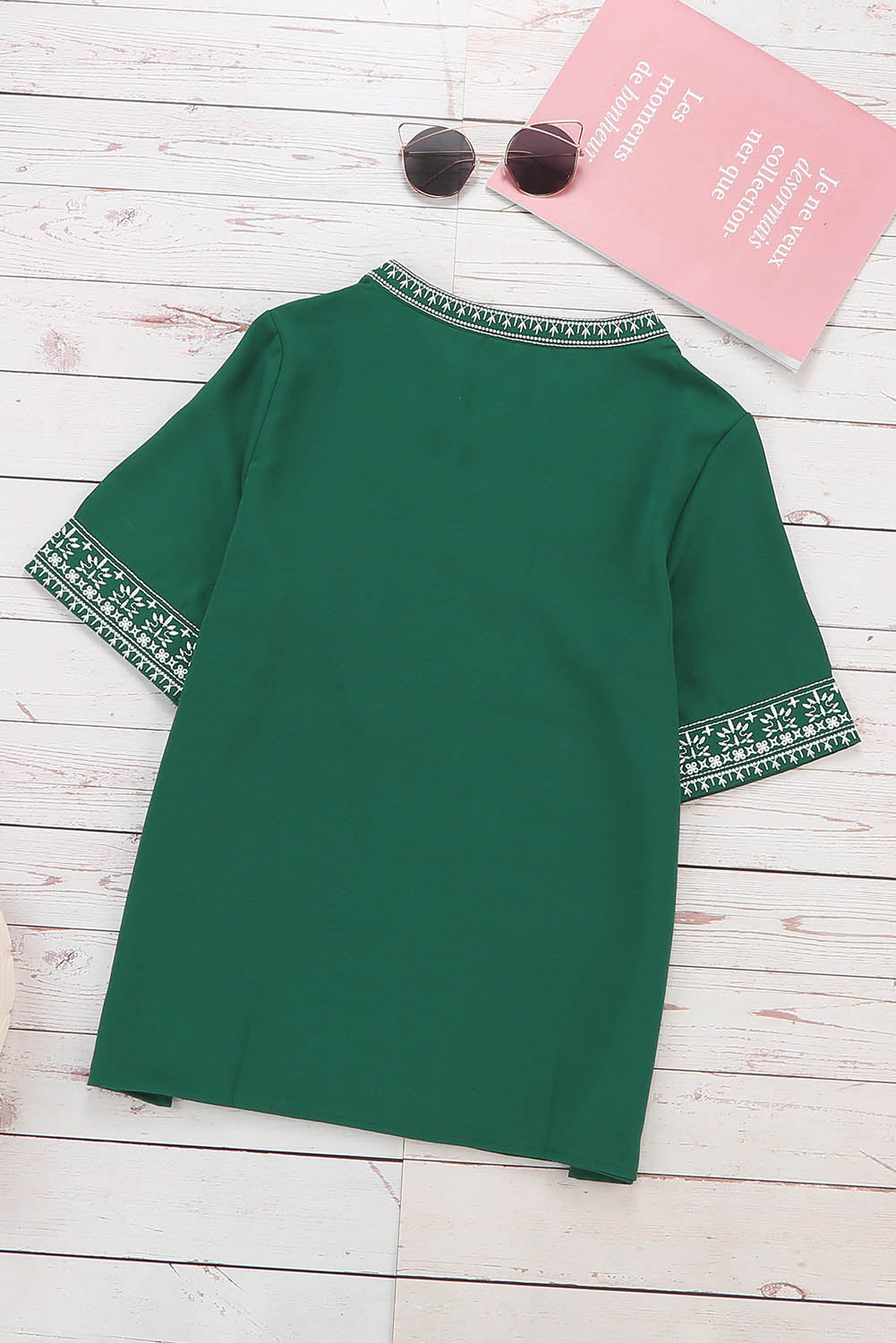 A stylish green boho blouse featuring a v-neckline and half sleeves with floral details, perfect for casual outings.