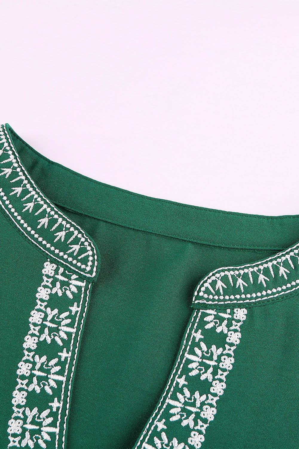 A stylish green boho blouse featuring a v-neckline and half sleeves with floral details, perfect for casual outings.