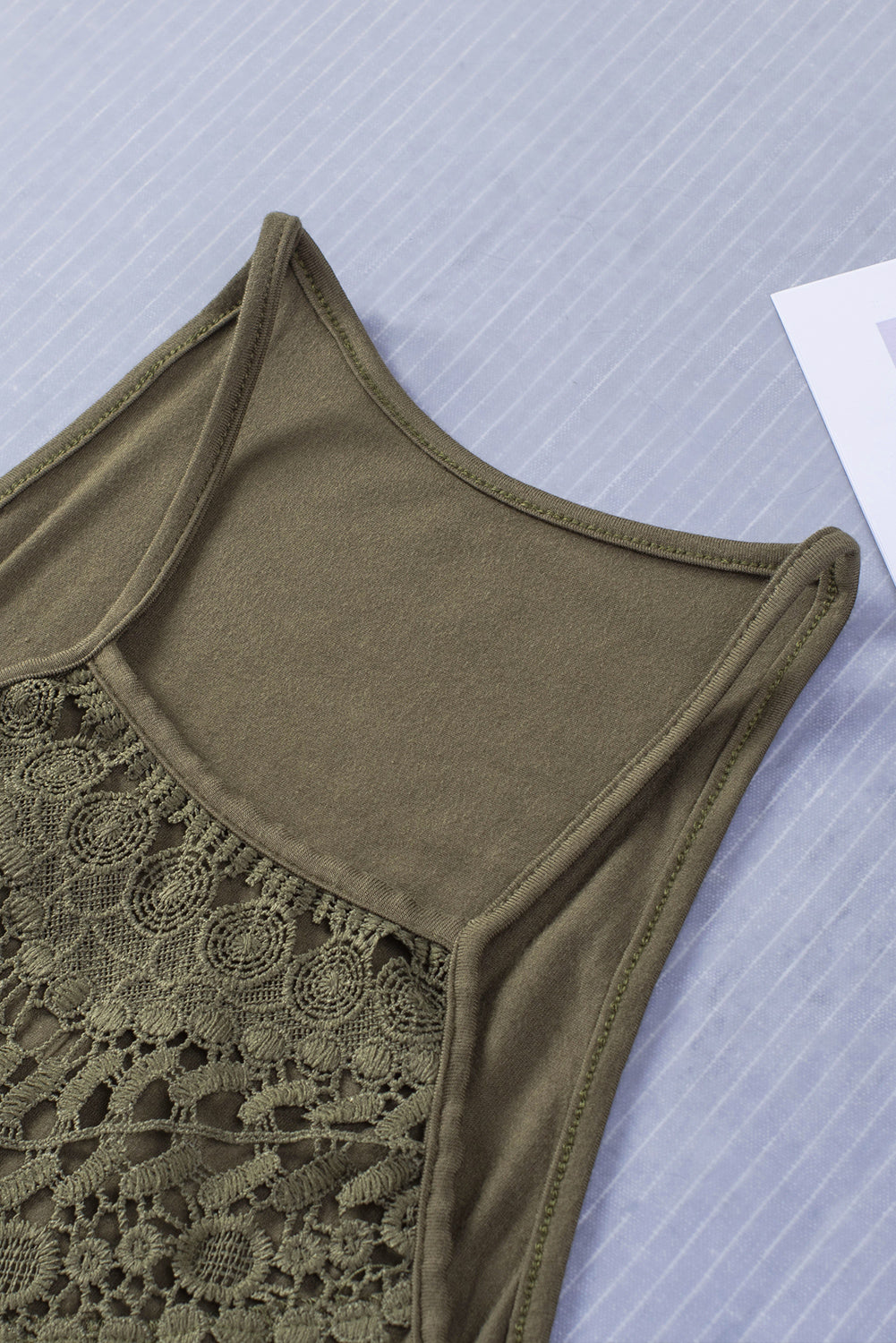 A stylish green tank top featuring intricate crochet lace detailing on the yoke, perfect for summer wear.