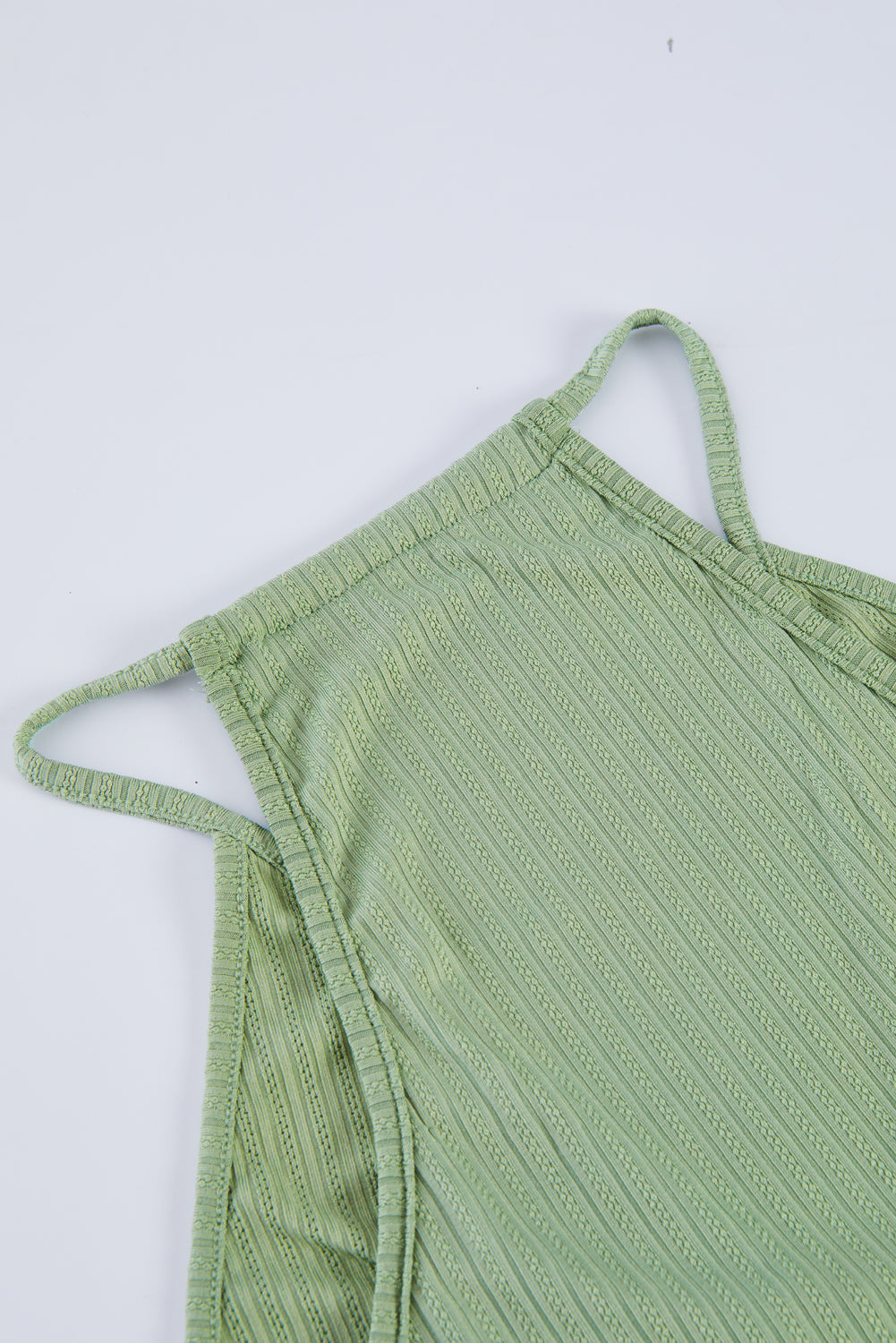 A stylish green deep V neckline ribbed babydoll tank top, perfect for summer wear, showcasing its lightweight knit material and flattering design.