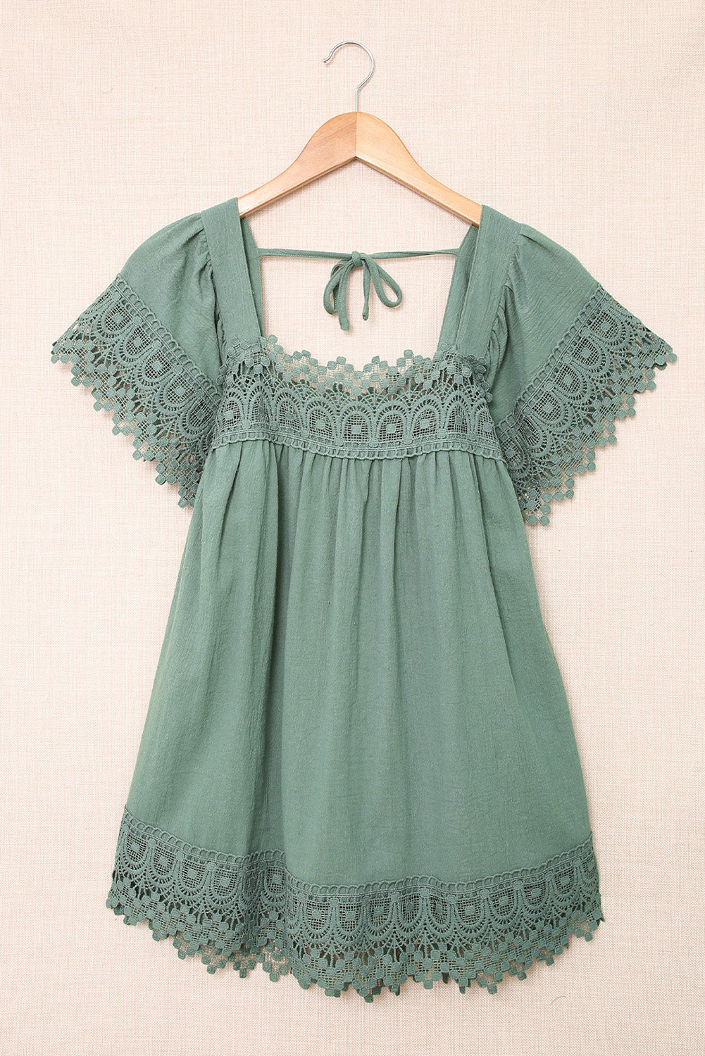 A stylish green blouse featuring lace and pom pom splicing, with a square neck and open back design, perfect for various occasions.