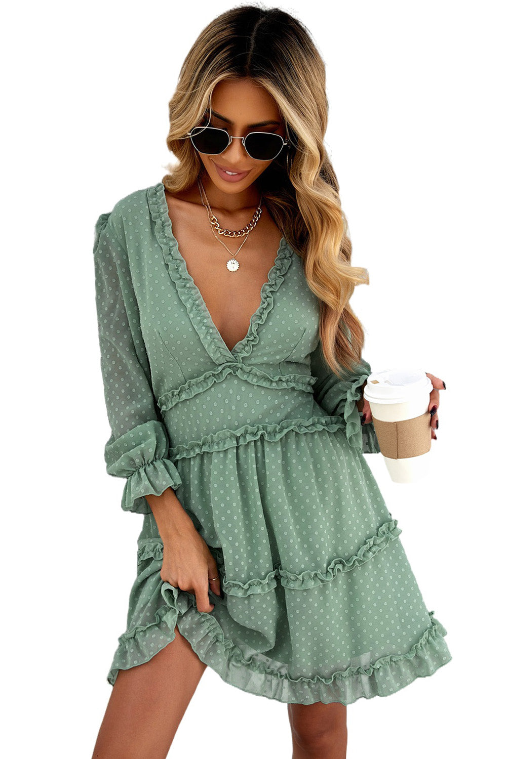 A stylish green mini dress featuring layered ruffles, puff sleeves, and an open back design, made from Swiss dot fabric.