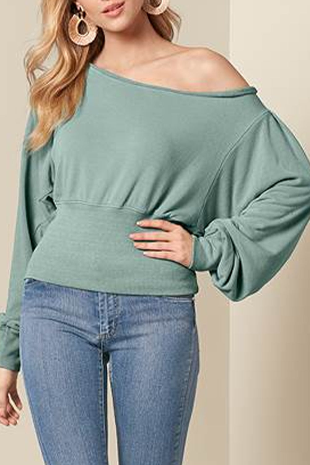 A stylish green off shoulder blouse with bishop sleeves and a cinched waist, perfect for winter fashion.