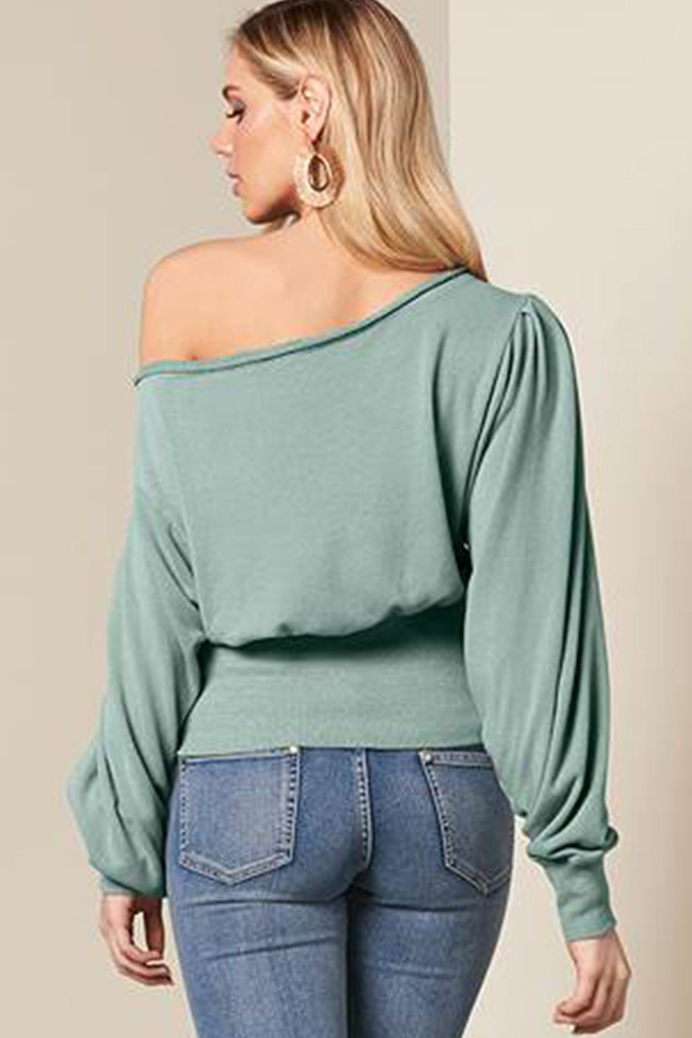 A stylish green off shoulder blouse with bishop sleeves and a cinched waist, perfect for winter fashion.